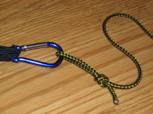 Attach a simple cord to the ring to use for attaching to the hammock and adjusting tension.